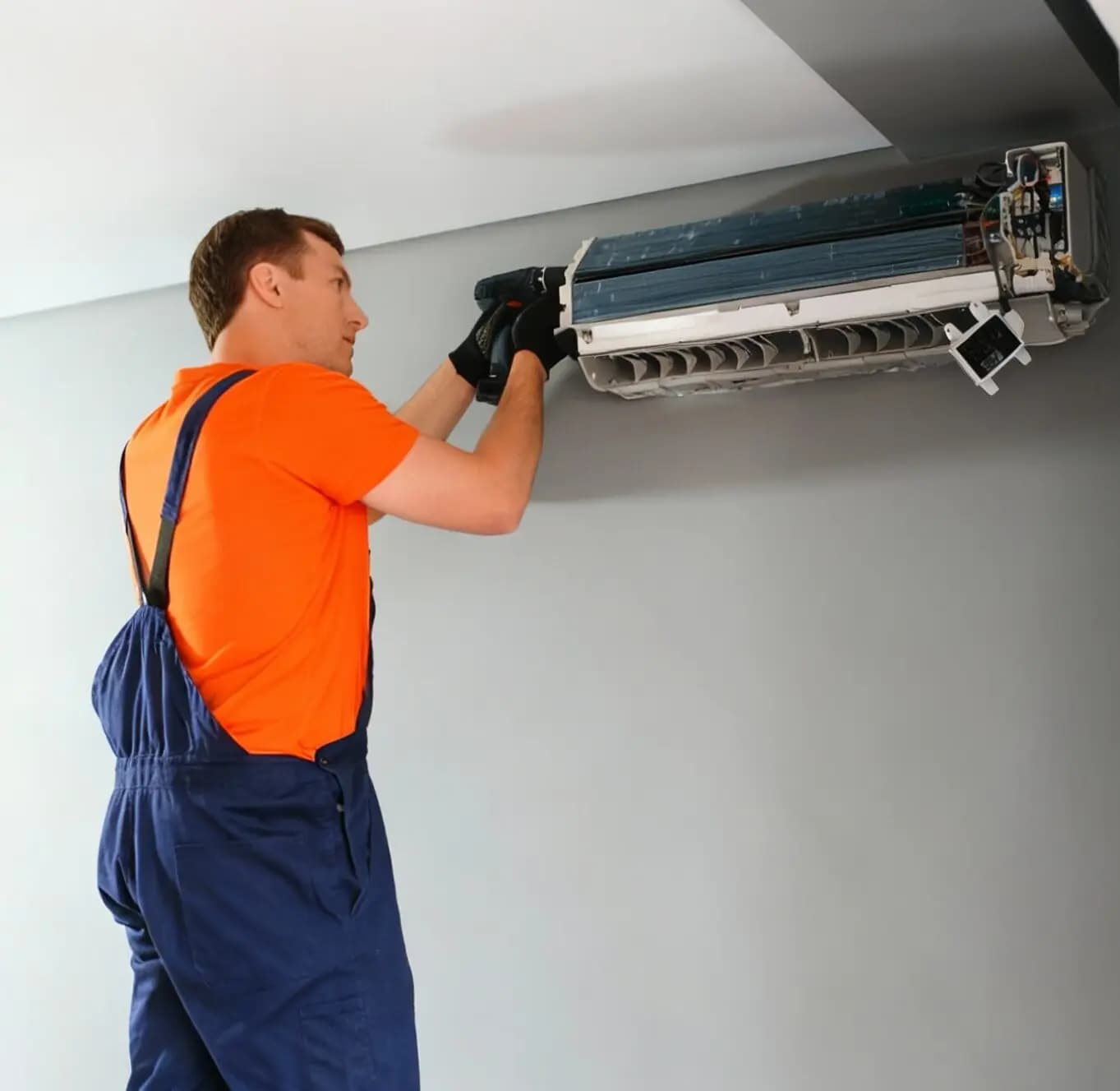 Technician installing a wall-mounted air-conditioning unit
