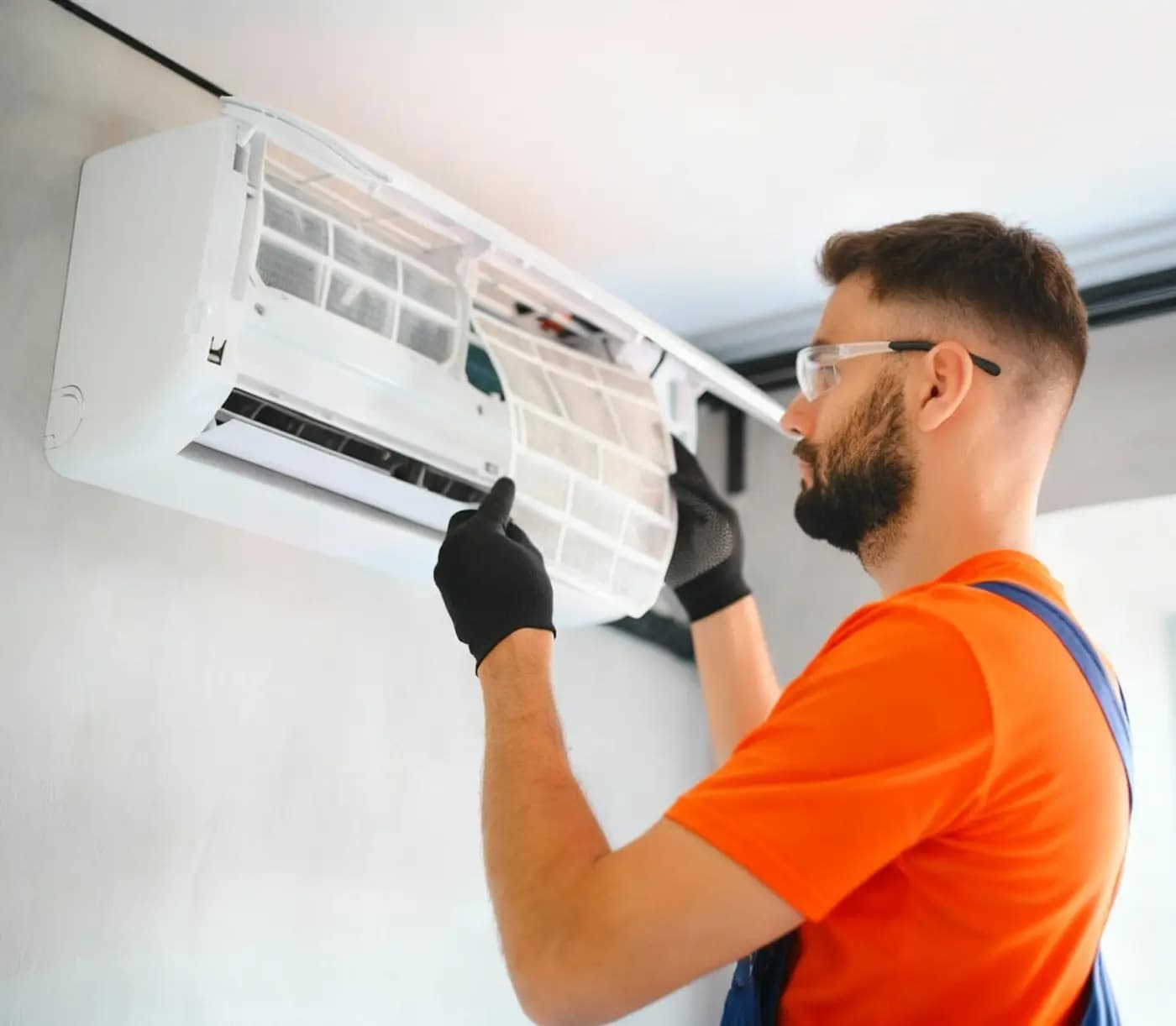 Technician maintaining a wall-mounted air-conditioning unit