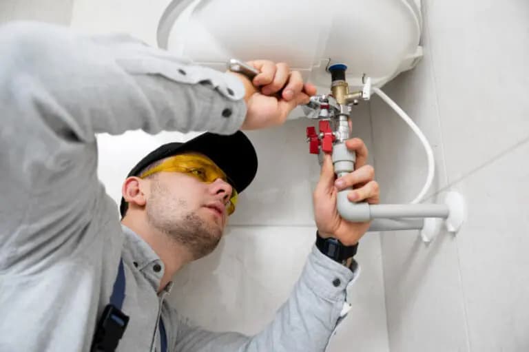 Engineer using a spanner on accessible heating and hot-water pipe connections