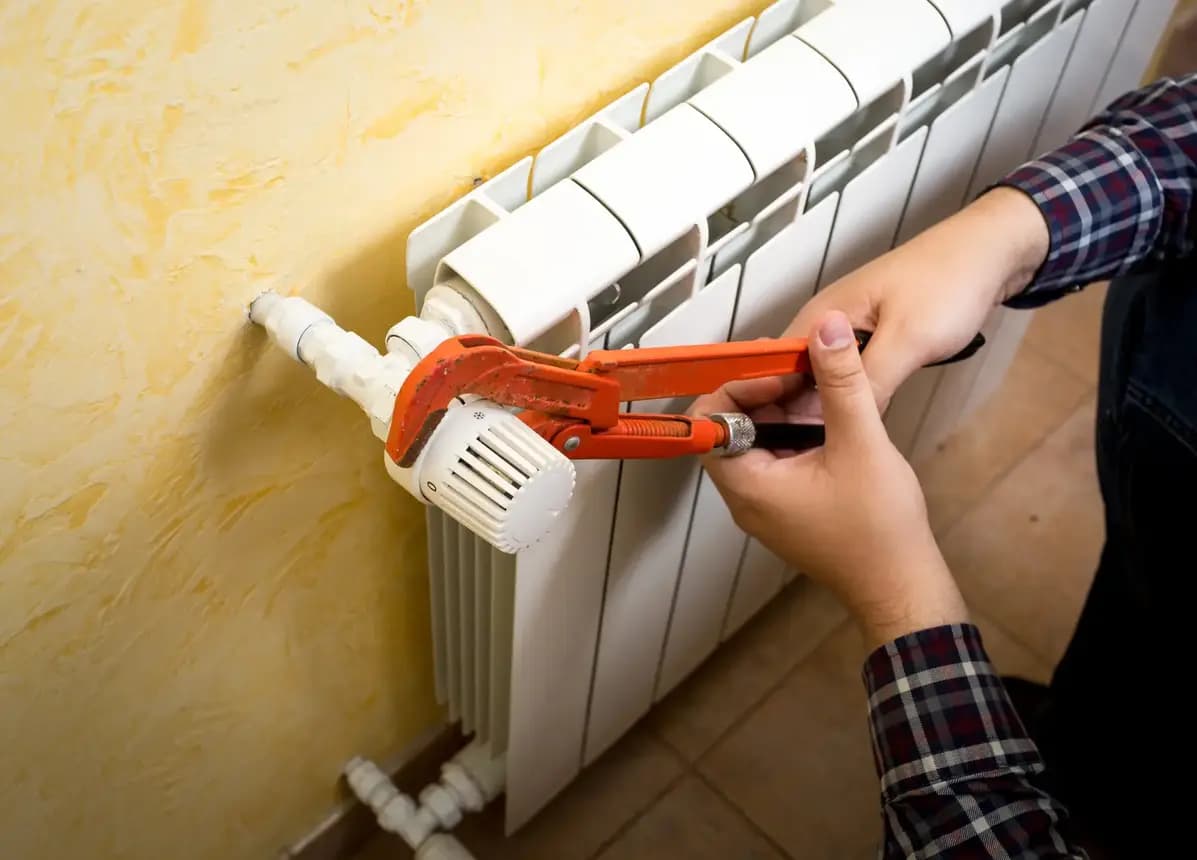 Engineer working on a radiator valve and control connection