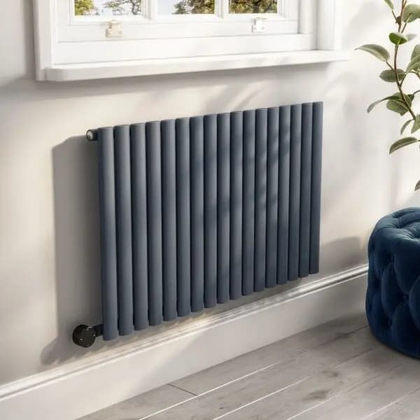 Modern central-heating radiator beneath a window in a Guildford home
