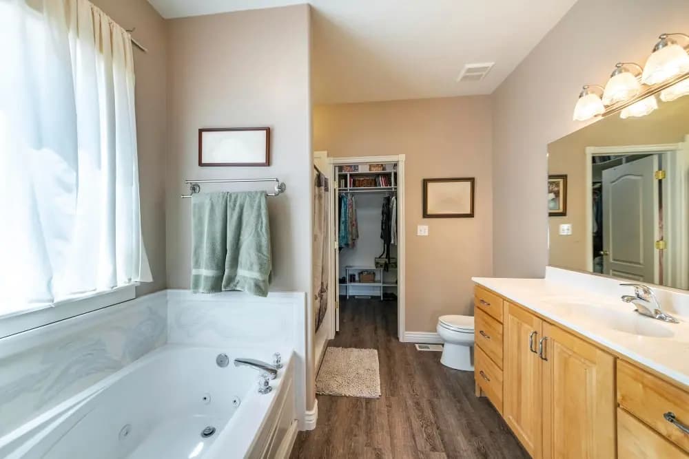 Bathroom with a toilet, basin and bath arranged around existing plumbing positions