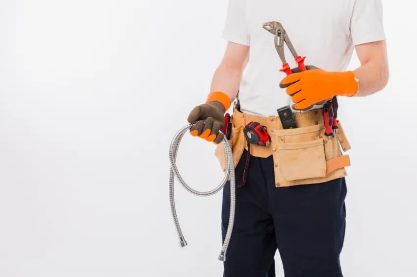 Emergency plumber holding pipework and plumbing tools in Surbiton